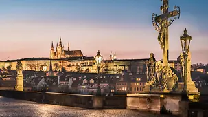Blick auf die beleuchtete Karlsbrücke in Prag in der Abenddämmerung.