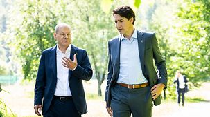 Bundeskanzler Olaf Scholz im Gespräch mit Kanadas Premierminister Justin Trudeau bei einem Spaziergang.