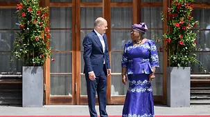 Rngozi Okonjo-Iweala in einem traditionellen Gewand bei der Begrüßung mit Bundeskanzler Olaf Scholz.