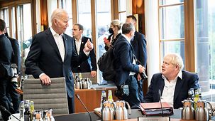 At the conference table, Joe Biden talks to Boris Johnson.