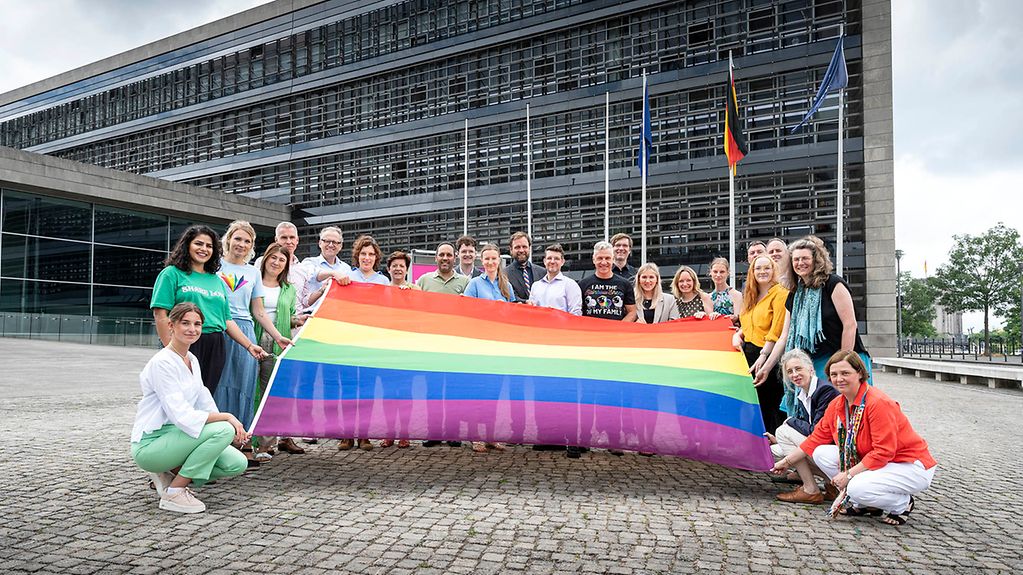 Foto zeigt Mitarbeiter des BPA mit der Regenbogenflagge