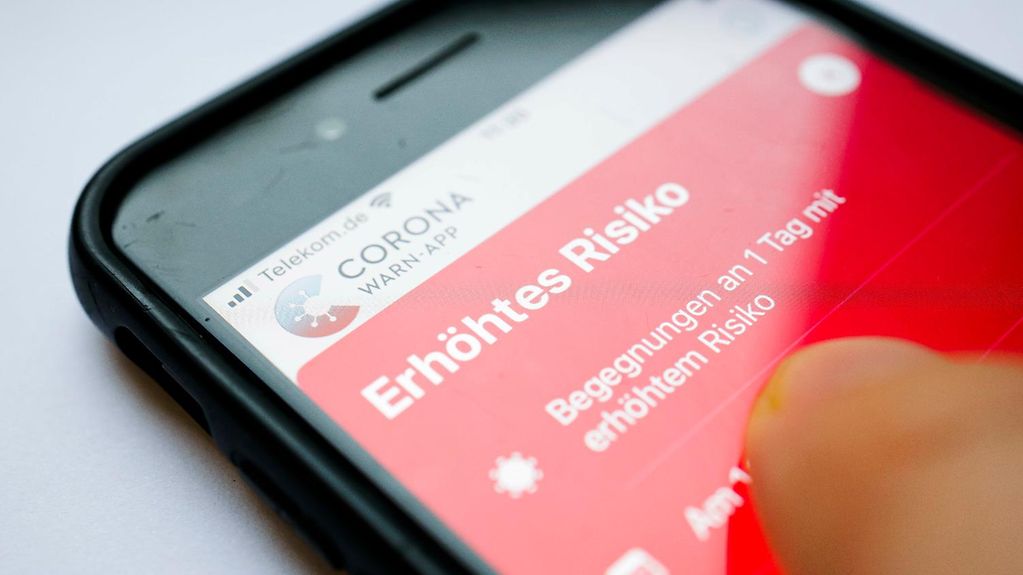 Die Corona Warn App zeigt auf einem Smartphone den Schriftzug Erhöhtes Risiko an. Risikobegegnungen