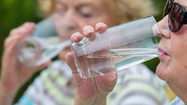 Zwei ältere Frauen trinken an einem heissen Sommertag ein Glas Wasser