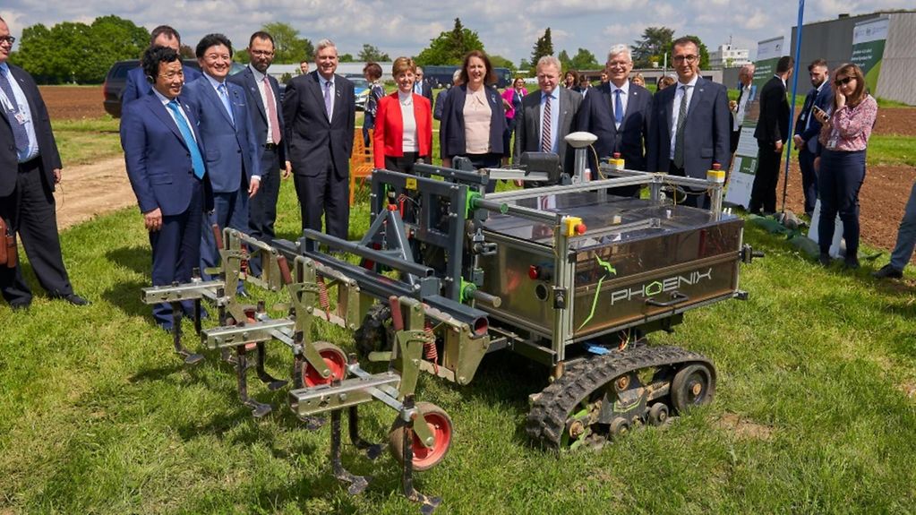 Das Bild zeigt die Agrarminister der G7-Staaten und einen Unkrautbekämpungsroboter.