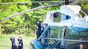 Barack Obama waves as he climbs into the helicopter.