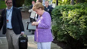 Bundeskanzlerin Merkel liest in Unterlagen.