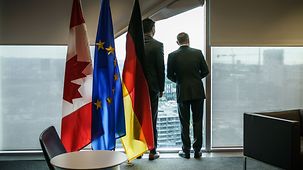 Bundeskanzler Olaf Scholz und Justin Trudeau, Kanadas Premierminister, stehen an einem Fenster.