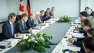 Le chancelier fédéral Olaf Scholz en discussion avec le premier ministre canadien Justin Trudeau en comité élargi