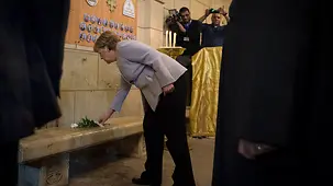Bundeskanzlerin Angela Merkel legt in der St.-Peter-und-Paul-Kirche eine Rose in Gedenken an die Opfer eines Bombenanschlags nieder.