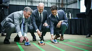 Bundeskanzler Olaf Scholz und Justin Trudeau, Kanadas Premierminister, beim Test eines Spielzeugautos mit Wasserstoffantrieb.