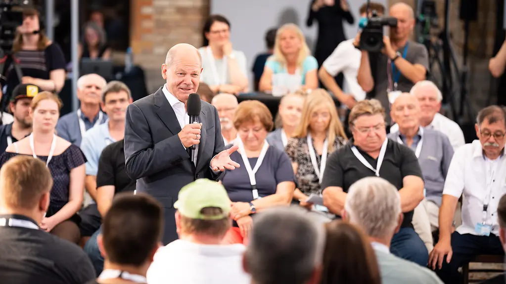 Federal Chancellor Olaf Scholz talking to members of the public.