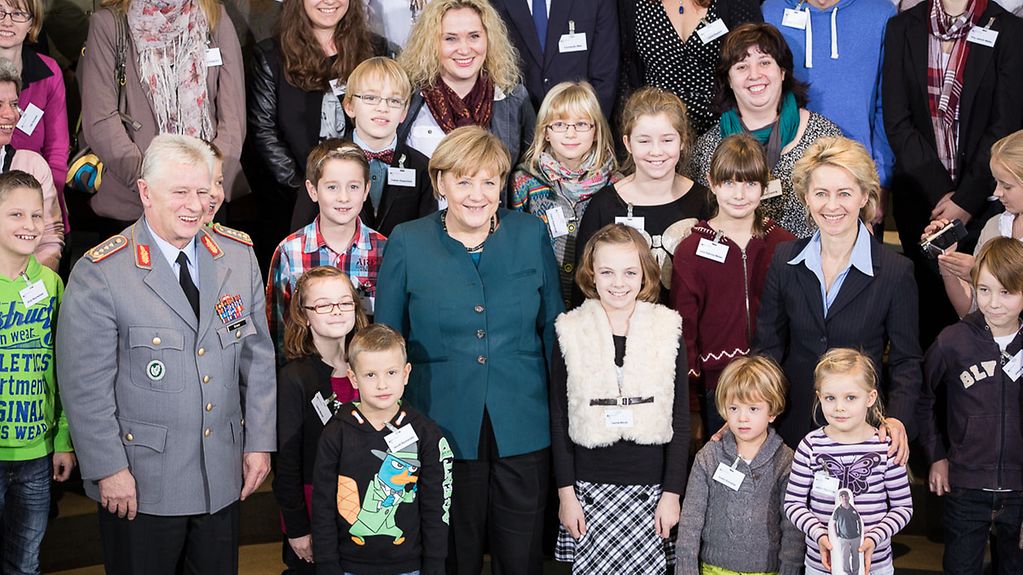 Bundeskanzlerin Angela Merkel und Ursula von der Leyen, Bundesministerin der Verteidigung, posieren mit Angehörigen von Soldaten im Auslandseinsatz.