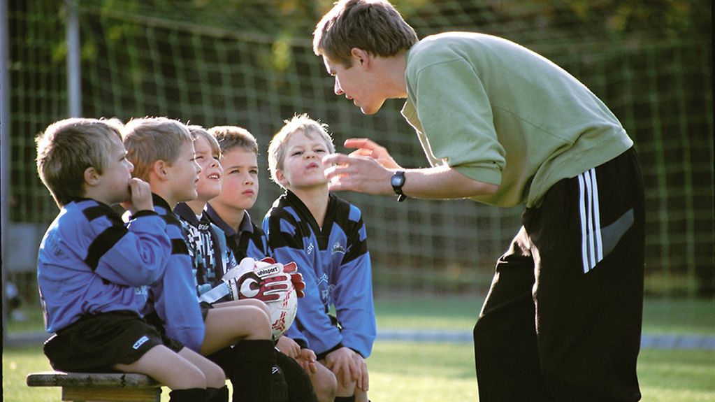 Fußballtrainer mit fünf kleinen Jungen.