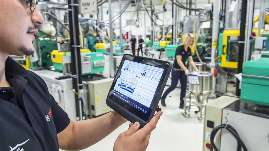 Ein Mitarbeiter der Robert Bosch GmbH überprüft im Bosch Werk in Immenstadt (Bayern) mit einem Tablet die Betriebsdaten von vernetzten Maschinen für Metallspritzguss.