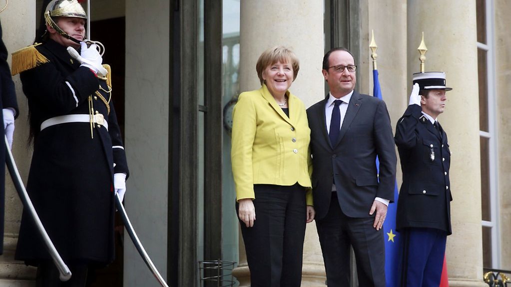 Der französische Präsident François Hollande begrüßt Bundeskanzlerin Angela Merkel am Elysee-Palast.
