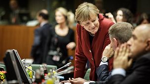 Bundeskanzlerin Angela Merkel unterhält sich vor Beginn der ersten Sitzung.