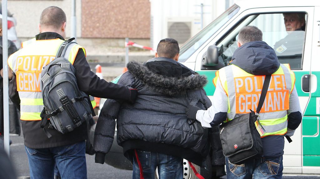 Polizisten begleiten einen straffällig gewordenen Asylbewerber zum Flughafen Leipzig-Halle zu seinem Abflug.
