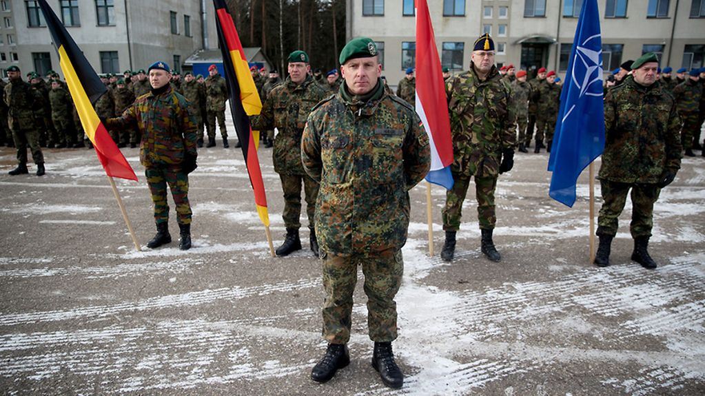 Soldaten vor verschiedenen Flaggen.