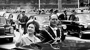 Theo Burauen, Oberbürgermeister von Köln, fährt mit Königin Elizabeth II. von Großbritannien im offenen Wagen durch die Stadt.
