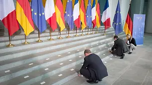 Mitarbeiter legen die Namensschilder auf die Stufen des Foyers