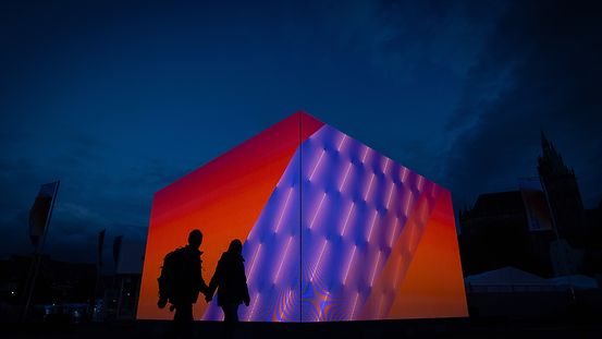 Der LED-Cube der Bundesregierung leuchtet am Abend auf dem Domplatz von Erfurt