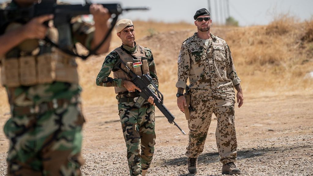 Sur la photographie, un soldat allemand et des soldats iraquiens en Iraq
