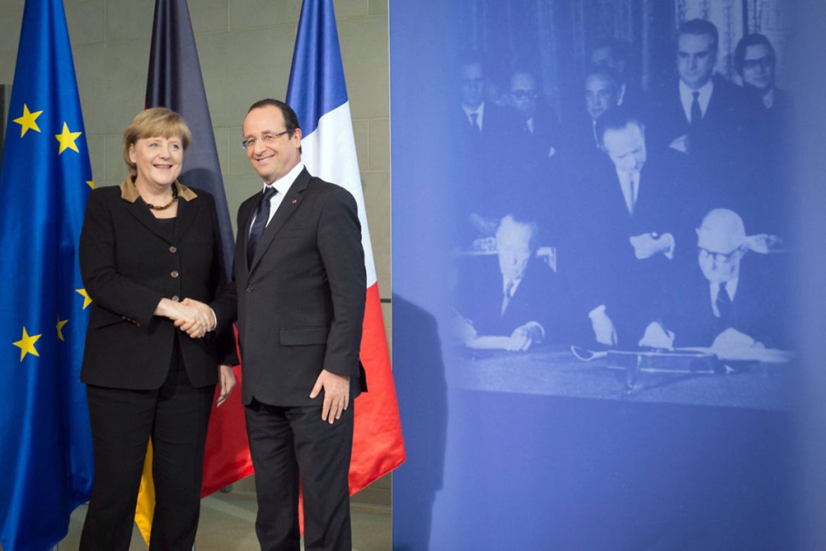 Merkel und Hollande schütteln sich vor einem Foto die Hände.