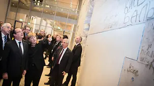 Merkel und Hollande vor der mit Graffiti beschriebenen Wand.