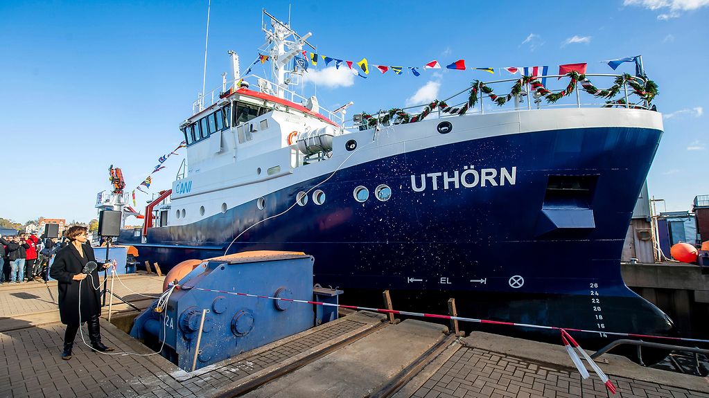 Bundesforschungsministerin Bettina Stark-Watzinger (vorner) tauft das neue Forschungsschiff "Uthörn II" (im Hintergrund)