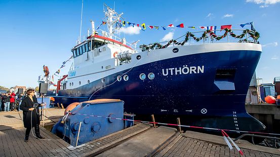 Bundesforschungsministerin Bettina Stark-Watzinger (vorner) tauft das neue Forschungsschiff "Uthörn II" (im Hintergrund)