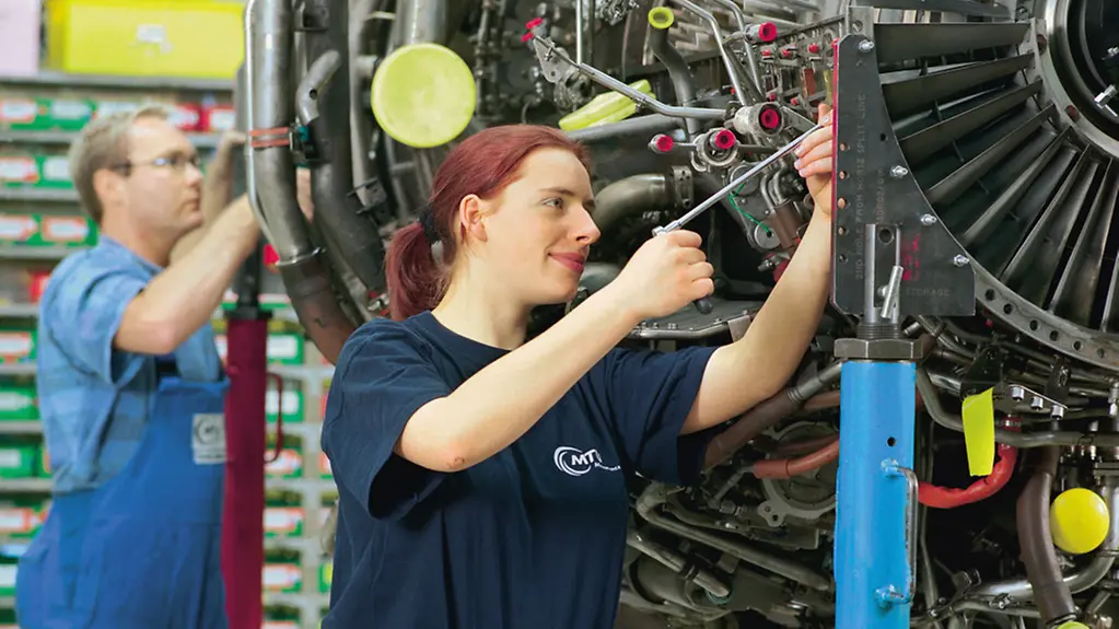 Triebwerk-Mechanikerin bei Instandhaltungsarbeieten an Flugzeugturbinen