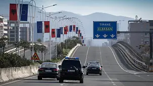 Autos fahren auf einer dreispurigen Straße Richtung Tirana.