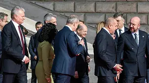Bundeskanzler Olaf Scholz im Gespräch beim Gang zum Familienfoto.