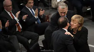 Merkel und Hollande umarmen sich.