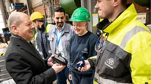 Bundeskanzler Olaf Scholz hält ein Mini-U-Boot in den Händen.