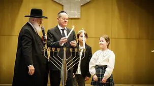 Bundeskanzler Olaf Scholz entzündet eine Kerze eines Chanukka-Leuchters.