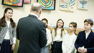 Bundeskanzler Olaf Scholz spricht mit Schülerinnen und Schülern.