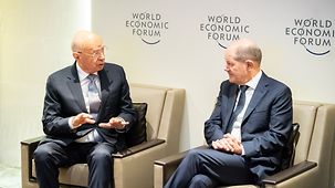 Bundeskanzler Olaf Scholz spricht beim Weltwirtschaftsforum in Davos mit Klaus Schwab.