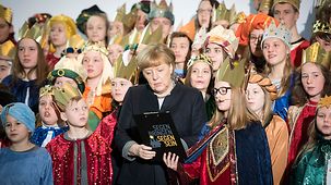 Bundeskanzlerin Angela Merkel singt mit Sternsingern.