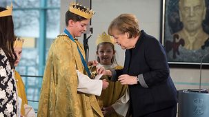 Bundeskanzlerin Angela Merkel spendet für die Sternsinger.