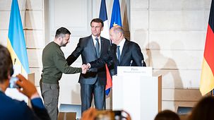 Bundeskanzler Olaf Scholz gibt Wolodymyr Selensky, ukrainischer Präsident, neben Emmanuel Macron, Frankreichs Präsident, die Hand.