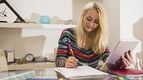 Eine Studentin sitzt am Schreibtisch.