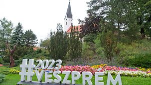 "Veszprem 2023" - Schriftzug zur Europäischen Kulturhauptstadt in einer Grünanlage.