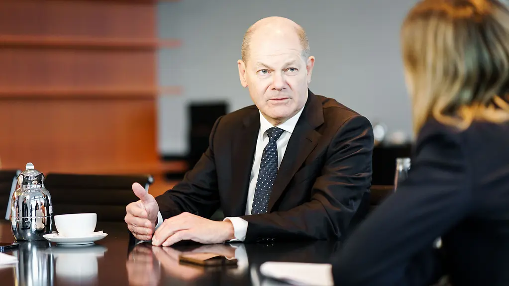 Bundeskanzler Scholz sitzt am Tisch während eines Interviews mit der BILD-Zeitung.