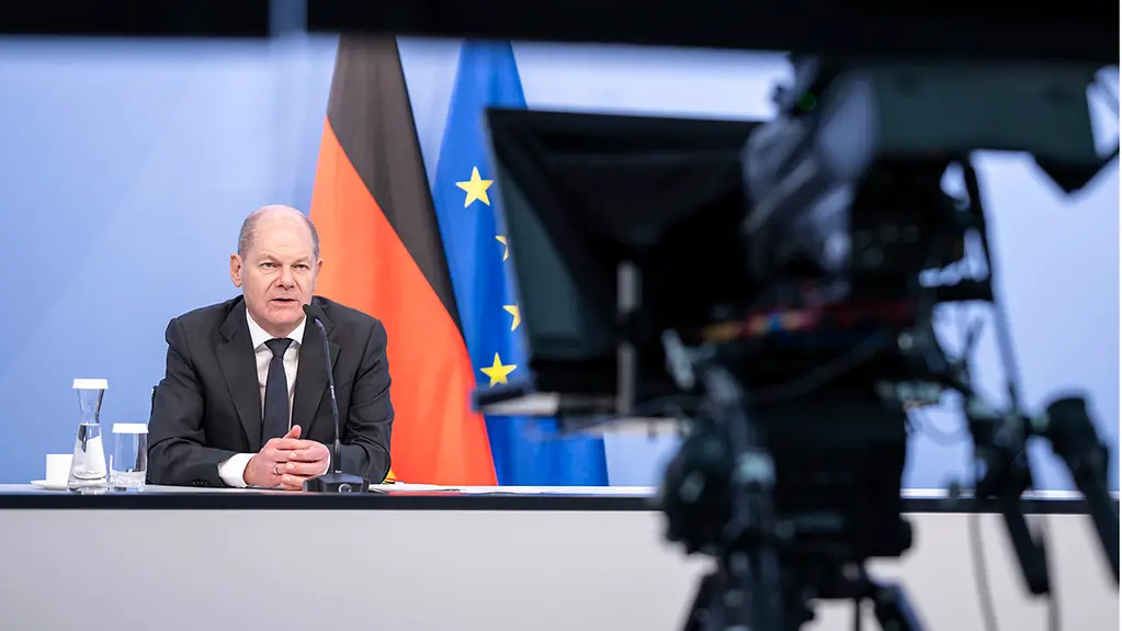 Federal Chancellor Scholz looking into a video conference camera.