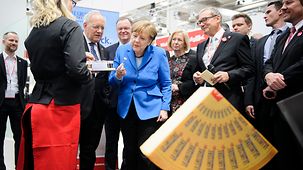 Chancellor Angela Merkel and Swiss President Johann Schneider-Ammann tour the trade fair.