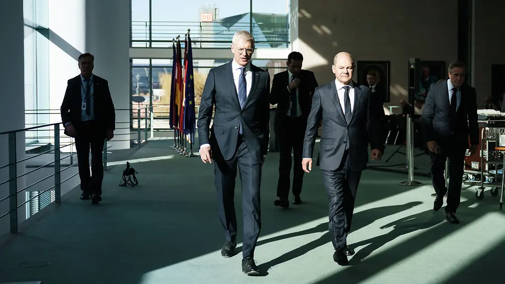 Bundeskanzler Olaf Scholz geht neben Krisjanis Karins, Lettlands Ministerpräsidenten.