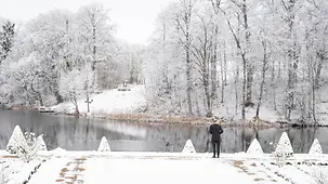 Bundeskanzler Olaf Scholz steht im verschneiten Garten am Rande der Kabinettsklausur auf Schloss Meseberg.