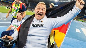 Daniel Scheil jubelt mit einer Deutschlandfahne über die gewonnene Goldmedaille.