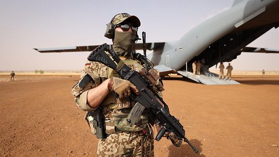 A soldier guards a plane of the Federal Armed Forces in Niger.